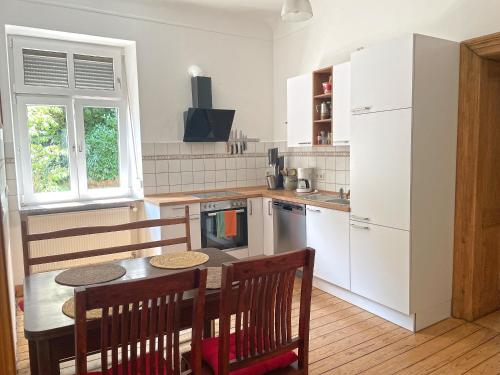 uma cozinha com uma mesa e cadeiras e um frigorífico em Au Bel Étage em Saarbrücken