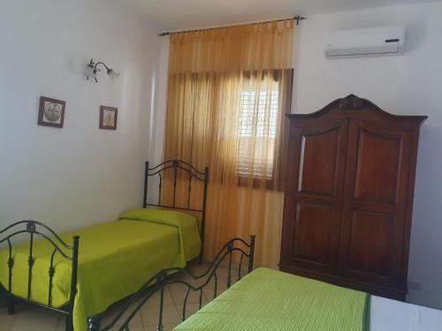 a bedroom with two beds and a wooden cabinet at Azzurro mare in Arenella