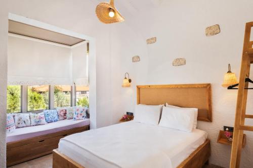 a bedroom with a large bed and a window at Armel Alaçatı in Alacati