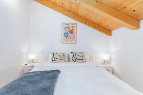 biała sypialnia z łóżkiem i 2 lampami w obiekcie Stone house Istria w Puli