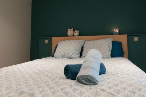 a bed with two cats sitting on top of it at Le Temps d'une Fugue in Lierneux