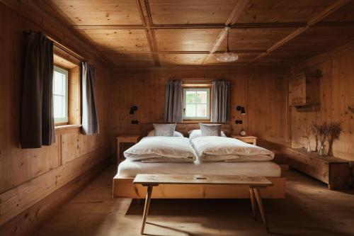 ein Schlafzimmer mit einem Bett in einem Holzzimmer in der Unterkunft Ostí Vedl in St. Martin in Thurn