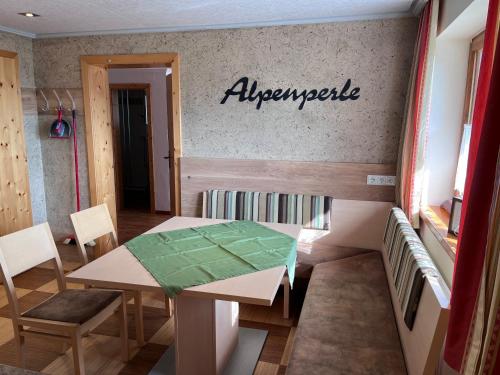 a table and chairs in a room with a sign on the wall at Apartment Alpenperle in Schladming