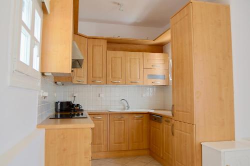 a kitchen with wooden cabinets and a sink at Ubud Mykonos in Agios Ioannis Mykonos