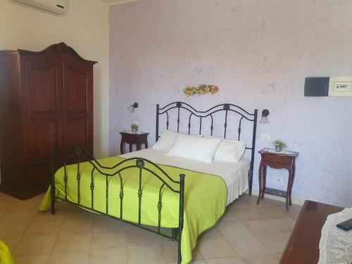 a bedroom with a bed with a green blanket at Azzurro mare in Arenella