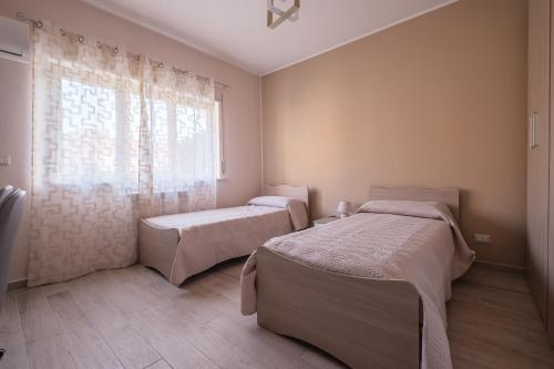 a bedroom with two beds and a window at Damilhouse 4 in Messina