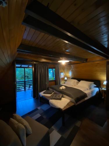 a bedroom with a large bed in a wooden house at Vikendica Bella in Bihać