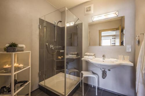 a bathroom with a glass shower and a sink at Haus Alpin in Ellmau