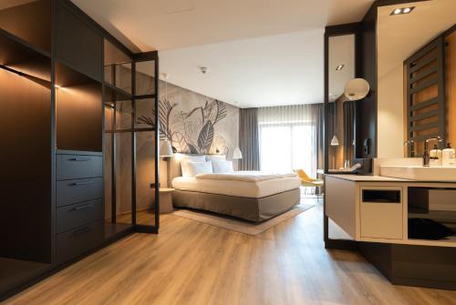 a bedroom with a bed and a bathroom with a sink at Thöles Hotel Bücken in Bücken