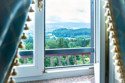 an open window with a view of the forest at Robenstein Hotel & SPA - Villa in Zwiesel