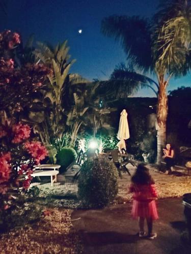 Ein kleines Mädchen, das nachts durch einen Garten geht. in der Unterkunft Il giardino di Stelle in Nunziata