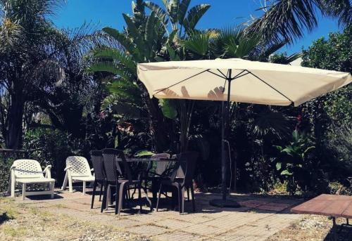 einen Tisch und Stühle unter einem Sonnenschirm auf einer Terrasse in der Unterkunft Il giardino di Stelle in Nunziata