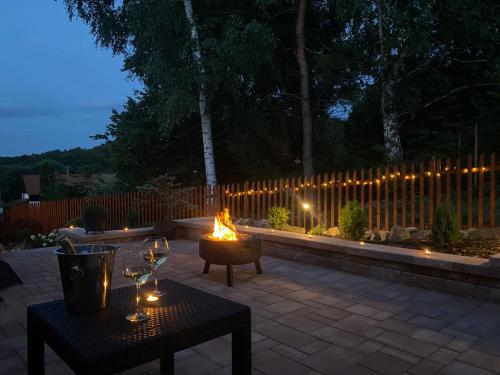 a patio with two tables and a fire pit with lights at Apartmán Danuše in Česká Lípa