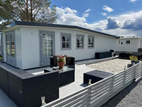 een wit gebouw met een terras met een patio bij Odin Camping AS in Svensrud