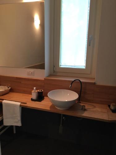ein Badezimmer mit einem weißen Waschbecken auf einer Holztheke in der Unterkunft The House on the lake shore in Dervio