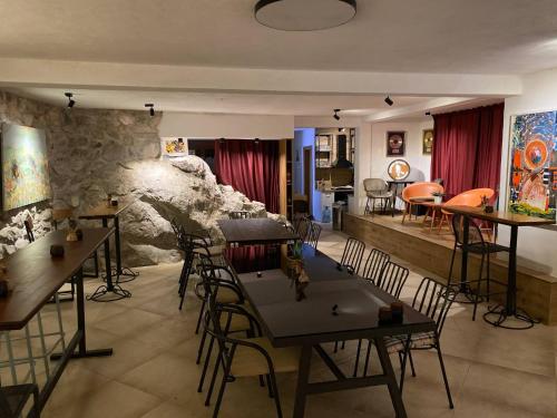 Pokój ze stołami i krzesłami oraz kamienną ścianą w obiekcie The Rock Stars Villa With Private Pool And Beach w mieście Danilovgrad