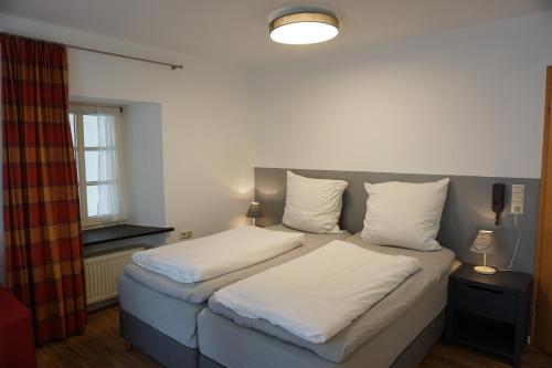 a bedroom with two beds with white sheets and a window at Feriengut Bohn in Bernkastel-Kues