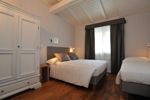 um quarto com 2 camas e uma janela em Baita Fanti Ski & Bike em Bormio