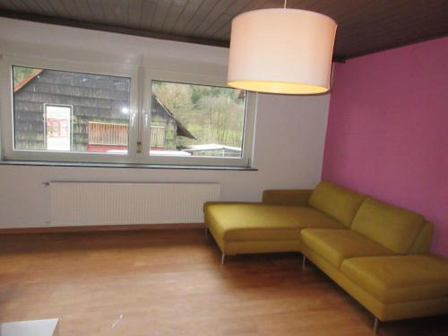 a living room with a couch and a window at Ferienwohnung in Waldnähe in Mossautal