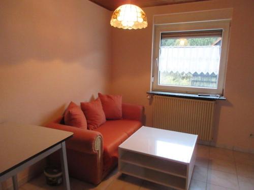 a living room with a couch and a window at Ferienwohnung in Waldnähe in Mossautal