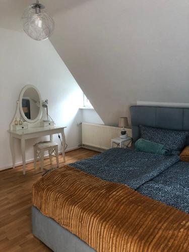 een slaapkamer met een bed en een tafel met een spiegel bij House of hanover in Hannover
