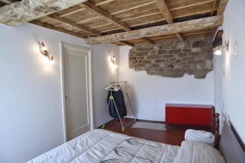 a bedroom with a bed and a stone wall at Appartamento da Vinci - Appartamento Masaccio in Corfino