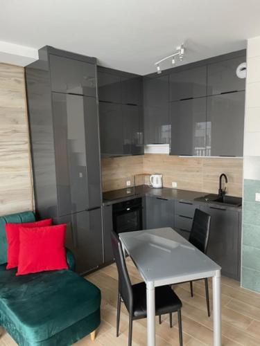 a kitchen with a table and a couch and a table and chairs at Apartament Boston Jastrzębia Góra in Jastrzębia Góra