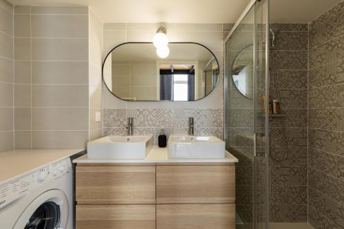 une salle de bain avec un lavabo et une machine à laver dans l'établissement DIFY Mazenod - Prefecture, à Lyon