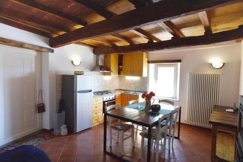a kitchen with a table and a refrigerator at Appartamento da Vinci - Appartamento Masaccio in Corfino