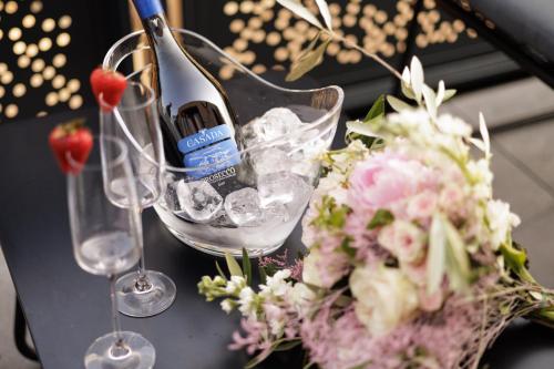 a bottle of wine and flowers on a table at Aparthotel Na Klenici in Mladá Boleslav