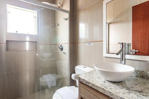 y baño con lavabo, aseo y espejo. en Pousada Dom Toazza, en Florianópolis