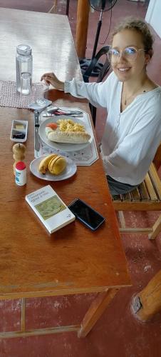 een vrouw die aan een tafel zit met een bord eten bij Sol's Inn - Port Barton in San Vicente