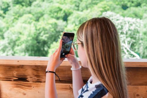a woman taking a picture with her cell phone at Vucja Gora in Foča