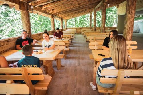 a group of people sitting at tables in a classroom at Vucja Gora in Foča