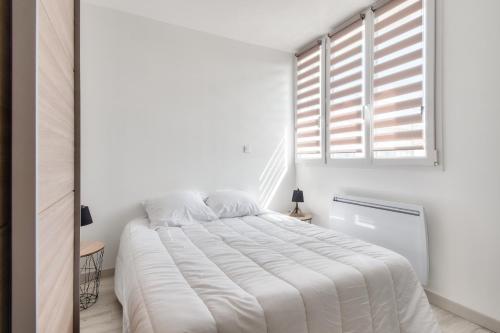 une chambre blanche avec un grand lit et une fenêtre dans l'établissement Appartement pour 4- Balcon- Plage des Becs, à Plage-des-Demoiselles