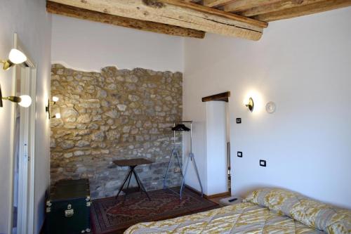 a bedroom with a bed and a stone wall at Appartamento da Vinci - Appartamento Masaccio in Corfino