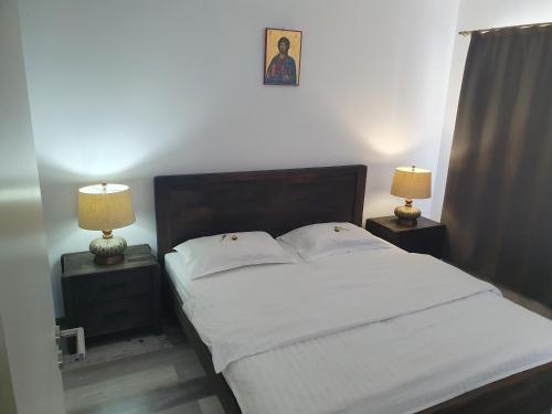 um quarto com uma cama branca com duas mesas de cabeceira em Luxury Apartments em Selimbar