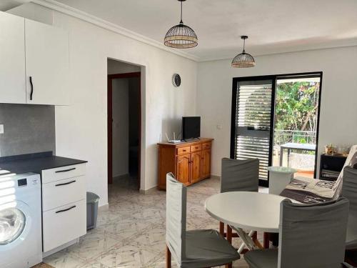 cocina y comedor con mesa, mesa y sillas en Apartment with Outdoor Pool and Air Conditioning in Cabo Roig, en Cabo Roig