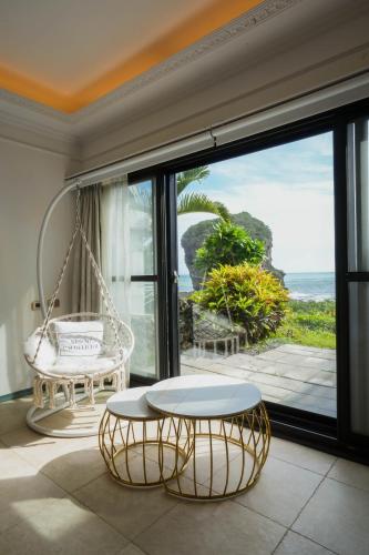 a room with a swing table and a view of the ocean at 墾丁曜星海-海景雙人包棟villa in Hengchun