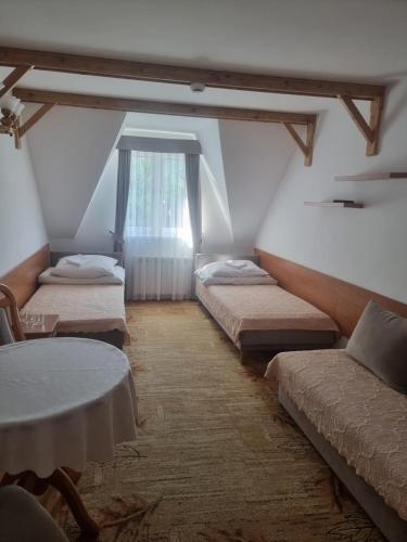 a room with three beds and a window at DW Janosik in Powrożnik