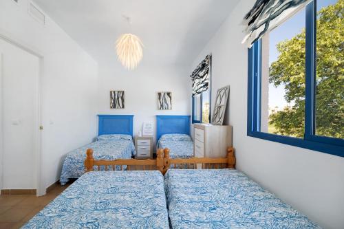 2 camas en una habitación con 2 ventanas en Casa en Costa Ballena, en Rota