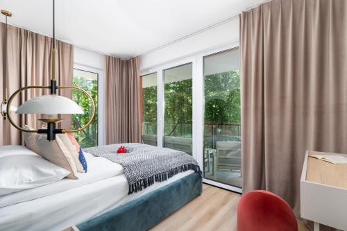 a bedroom with a bed and a large window at Stylish Apartment Wyspa Solna by Renters Prestige in Kołobrzeg