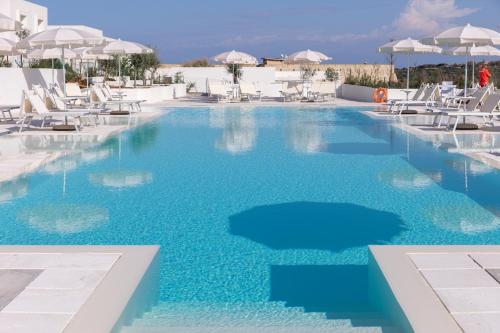 a swimming pool with blue water in a resort at Stunning Capo Falcone Charming Apartments 2 Bedrooms sleeps 6 in Stintino