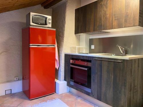 a kitchen with a red refrigerator and a microwave at LA FAVELA in Cully