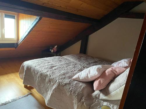 a bed in a room with a wooden ceiling at LA FAVELA in Cully
