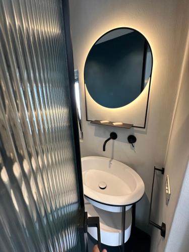 a small bathroom with a sink and a mirror at AccalmiA in Monopoli