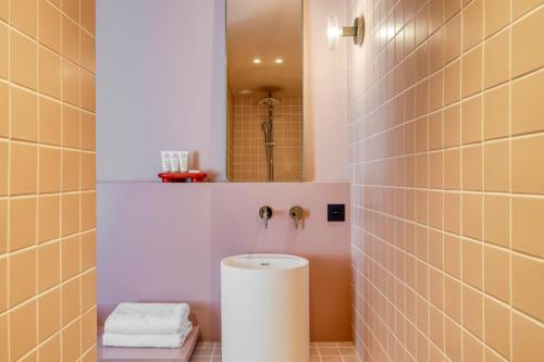 a bathroom with a toilet and a mirror at Maison Arya in Brussels