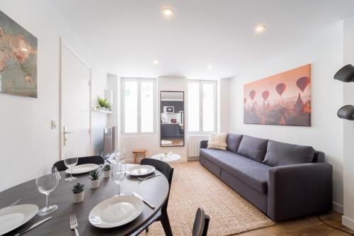 a living room with a couch and a table at Appart' Terrasse plein centre in La Ferté-Gaucher
