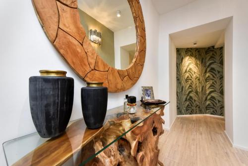 ein Raum mit zwei schwarzen Vasen und einem Spiegel in der Unterkunft Luxury Apartment Sunce in Rovinj