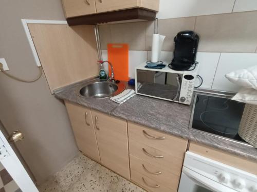 a small kitchen with a sink and a microwave at Apartamento Violeta in Aguadulce